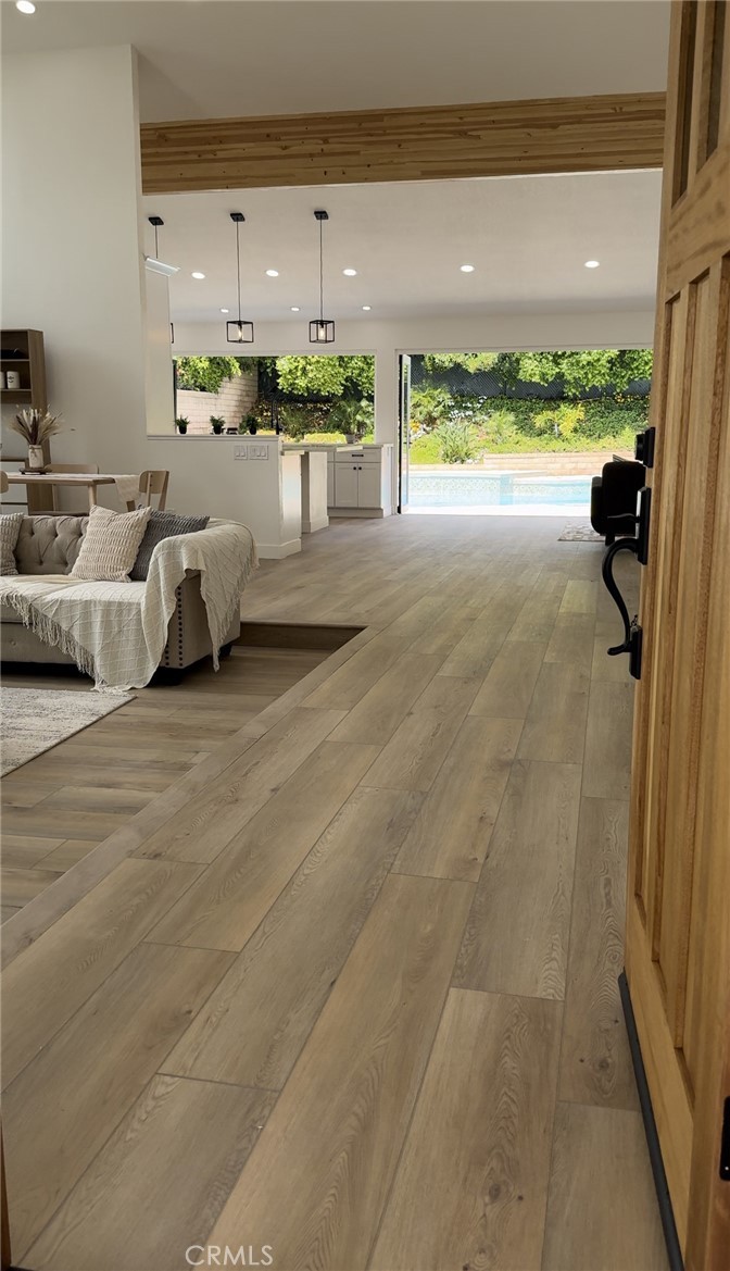 Open-concept living room with vaulted ceilings and white oak floors