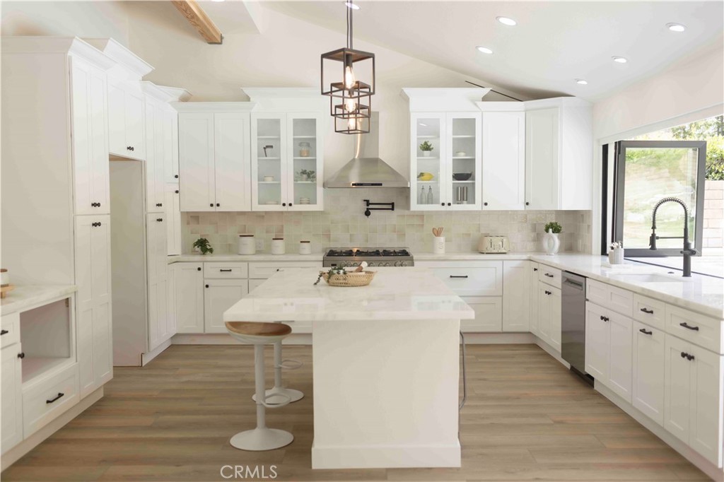 Remodeled white shaker kitchen with island and custom hood